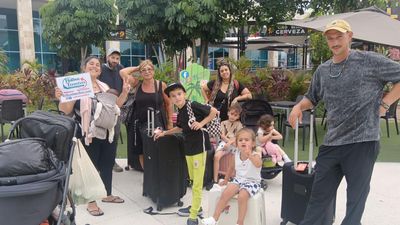 Familia con niños reunida cerca del muelle del ferry, sosteniendo el banner de Holbox Transfers mientras continúan hacia Holbox.