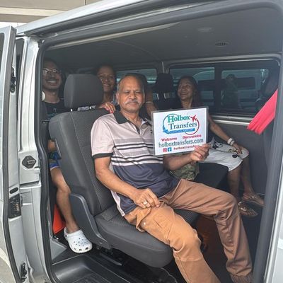 Una familia sentada junta en la van sostiene el banner de Holbox Transfers, todos sonriendo en su camino a Holbox.