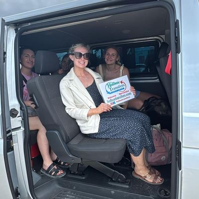 Un grupo de amigos apretado en la van presume el banner de Holbox Transfers, puras sonrisas rumbo a Holbox.